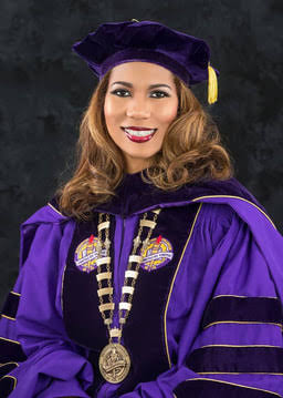 Dr. Roslyn Clark Artis in purple doctoral regalia with a chain of office.